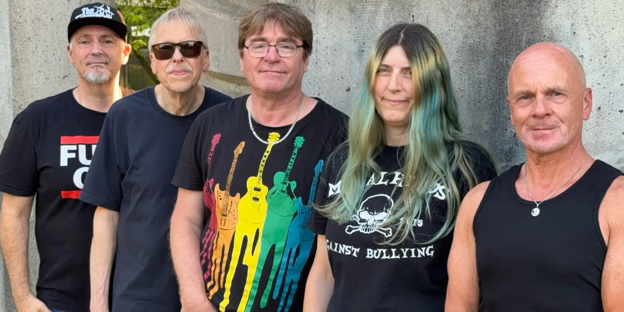 Die fünf Mitglieder von Ready N Rock stehen nebeneinander vor einer Betonwand.